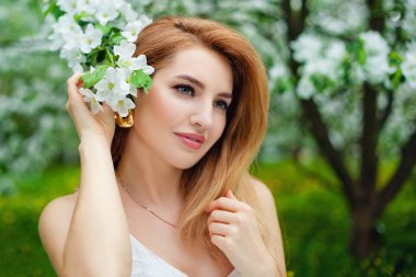 Elma çiçeği bahçesindeki güzel bir genç kızın portresi.