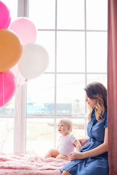 happy family on holiday with balloons sitting at the window