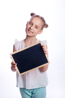 Beyaz arka planda boş bir tahta tutan küçük bir kız. Çocuk boş bir tahta gösteriyor. Eğitim kavramı