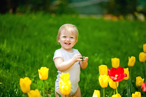 Kleines Kind Das Einem Schönen Frühlingstag Neben Tulpen Auf Dem — Stockfoto