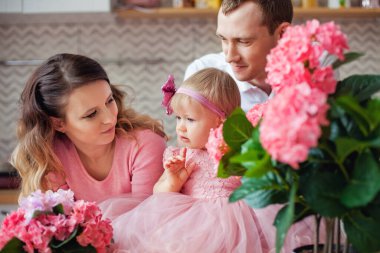 Bir çift ve küçük sevimli kızları kameraya bakarken gülümsüyorlar, aile portresi konsepti, mutlu ebeveynlik.