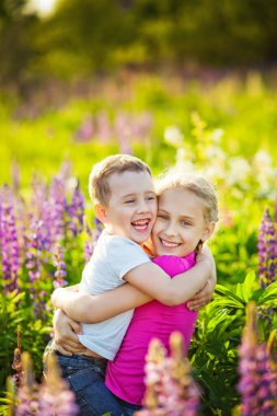 Abim ve ablam yazın kır çiçeklerinin arasında gülüp kucaklaşıyorlar.