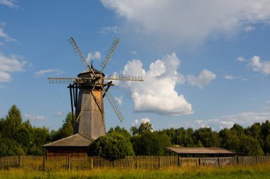 Geleneksel yel değirmeni ahşap evi yeşil çimlerin üzerinde ve açık mavi gökyüzünün altında