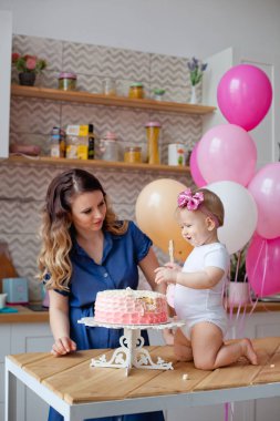 Aile masada, doğum günü pastası ve balonlarla.