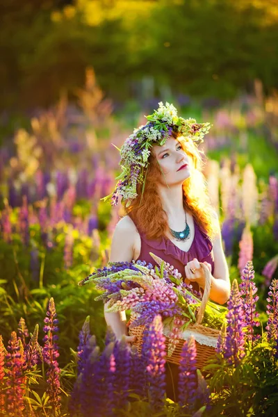 美しいです若いです女の子とともに赤い髪の花の花輪で彼女の頭の上に座っているフィールドで日没のライン夏 クローズアップ肖像画 — ストック写真