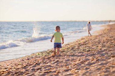 Sabun köpükleri, küçük erkek ve kız kardeşlerle sahilde oynayıp, sabun köpükleri üflüyor.