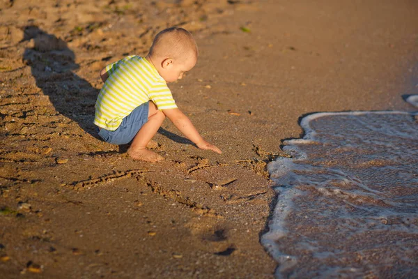 在海滨穿着条纹T恤的男孩 在海滩上奔跑的孩子暑假 日落的时候 快乐的孩子在海滩上玩耍 快乐的童年 — 图库照片
