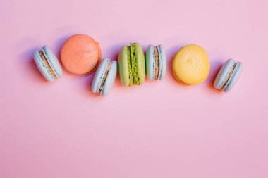 Renkli makarna kurabiyeleri, makarna keki ya da pembe arka planda makarna kurabiyeleri. Metin için boşluk