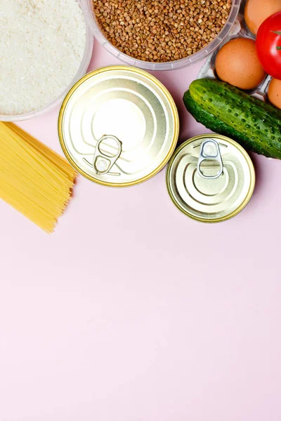 Food donations on wooden background, top view with copy spaceFood donations on a pink background, space for text