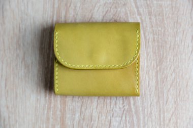 Açık yeşil, ahşap arka planda el yapımı deri bir cüzdan.