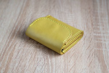 Açık yeşil, ahşap arka planda el yapımı deri bir cüzdan.