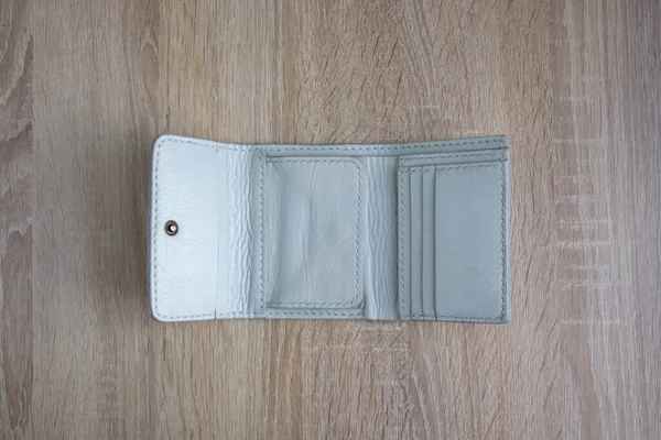 White leather wallet on a wooden tableWhite handmade leather wallet on a light wooden table