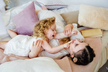 Sevgi dolu bir aile. Anne ve kızı oynaşıp sarılıyorlar. Sabahı birlikte geçireceğiz. Yatak odasında iyi oyunlar..