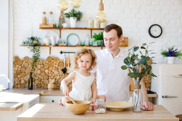 Mała Dziewczynka Bawi Się Jasnej Skandynawskiej Kuchni Przy Stole Ojciec — Zdjęcie stockowe