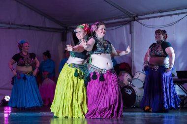 Çingene kostümlü kadın kabile dansçıları (cholis, uzun etekler, başlıklar ve gümüş takılar) sahnede sahne alırlar. Auckland, Yeni Zelanda, 14 Eylül 2019 