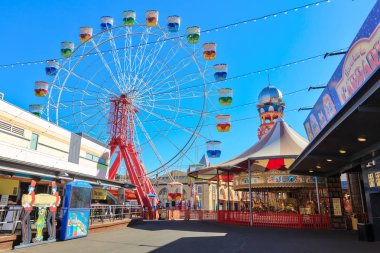 Sydney, Avustralya 'daki Luna Park' ta diğer binişlerin üzerinde yükselen dev bir dönme dolap. 30 Mayıs 2019 