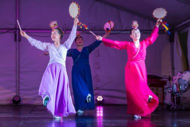 Renkli geleneksel Hanbok elbiseli Koreli bayan dansçılar, ellerinde davullar (Korece 'de 