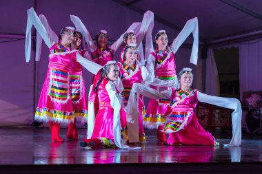 Renkli geleneksel halk kıyafetleri içinde bir grup Çinli dansçı sahnede poz veriyor. Auckland, Yeni Zelanda, 14 Eylül 2019 