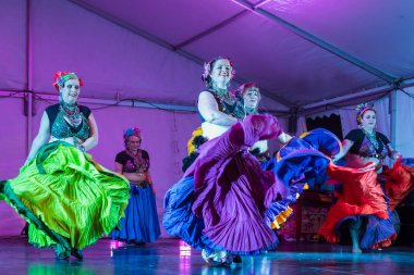 Tribal belly dancers in colorful gypsy costumes, making their skirts fly during a dance. Auckland, New Zealand, September 14 2019  clipart