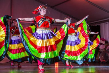 Çin, Xinjiang 'ın kadın halk dansçıları sahnede gösteri yapıyorlar. Uygur azınlık grubunun renkli geleneksel elbisesini giyiyorlar. Auckland 'da. Yeni Zelanda, 14 Eylül 2019 