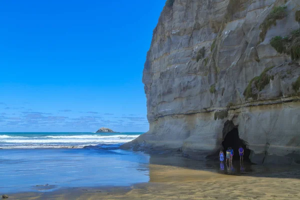 A small sea cave in towering coastal cliffs at Muriwai in the western Auckland Region, New Zealand