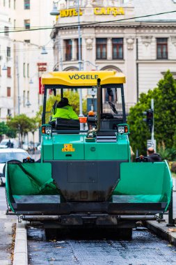 Bir sonbahar sabahında işçi tulumları giyip sokağı onarıyorlar.