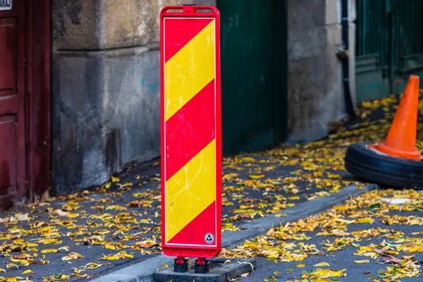 Parking spot with orange safety cones standing and autumn leaves — Stock Photo, Image