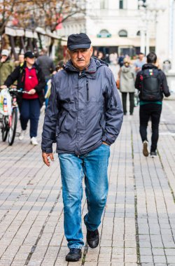 Timisoara şehir merkezindeki yaya bölgesinde yürüyen yaşlı bir adam., 