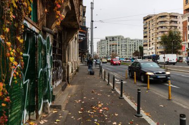 Sabahleyin kaldırımda yürümeye devam eden bir adam.
