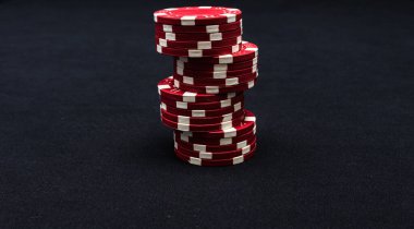 Siyah arkaplanda poker çipleri yığını.