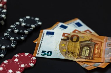 Poker fişleri ve siyah arka planda avrupa faturaları. Poker 