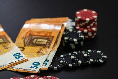 Poker fişleri ve siyah arka planda avrupa faturaları. Poker 