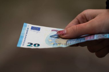 Kız elleri para veriyor. Bulanık bir çuvala Avro banknotları koymak