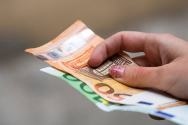 Kız elleri para veriyor. Bulanık bir çuvala Avro banknotları koymak