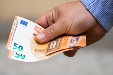 Erkek eli para verir. Bulanık sırtında Avro banknotları tutmak