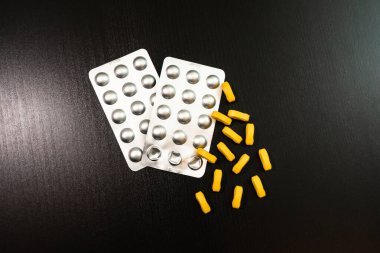 Siyah arka planda çok renkli vitaminler ve takviyeler. Kavram