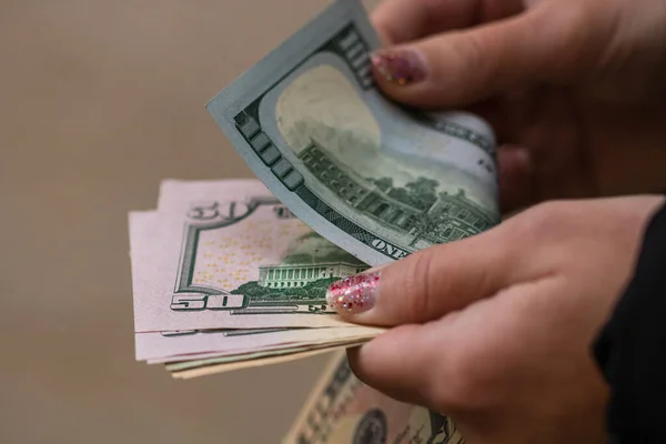 Girl hands counting money, counting dollars close up