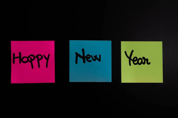 Psaní šťastný nový rok na barevné lepkavé poznámky. — Stock fotografie