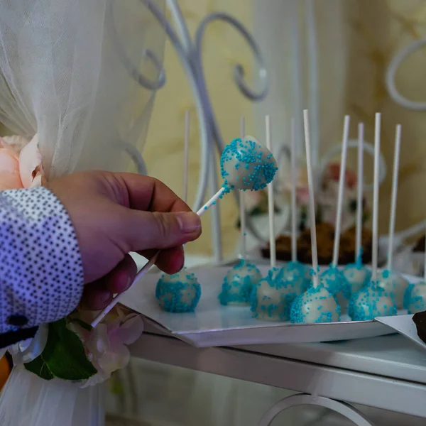 Male hand taking a colorful lollipop from a wedding candy bar. — Stock Photo, Image