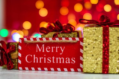 Mutlu Noel ahşap tabelası ve ışıltılı Noel hediyeleri. İsa