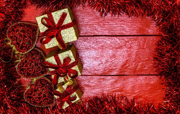 Kompozycja świąteczna na czerwonej drewnianej desce z girlandą świąteczną — Zdjęcie stockowe