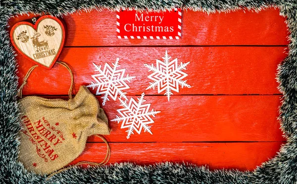 Kerstcompositie op rood houten bord met kerstslinger — Stockfoto
