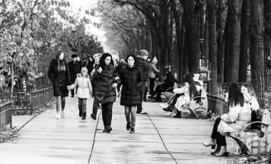 B şehir merkezindeki işlek caddede kışlık paltolu insanlar yürüyor.