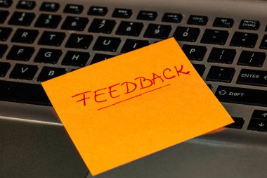 Renkli yapışkan nota geri bildirim yazılıyor. Geribildirim ile metin 