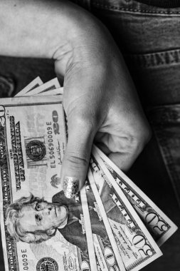 Kadın eli kot pantolonunun arka cebinden para alıyor. Saklanan kadın