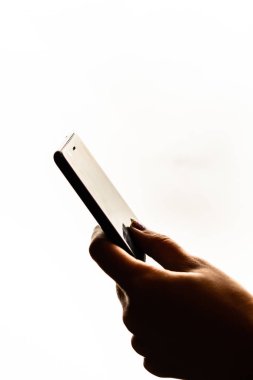 Elinde siyah bir akıllı telefon tutan bir kadın. Genç kız. 