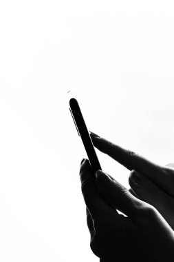 Elinde siyah bir akıllı telefon tutan bir kadın. Genç kız. 