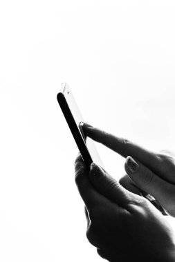 Elinde siyah bir akıllı telefon tutan bir kadın. Genç kız. 