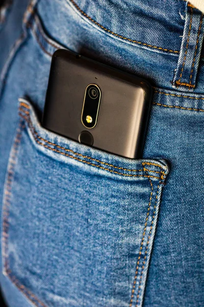 Sluit de smartphone in jeans achterzak. Bedrijfsleven en mode — Stockfoto