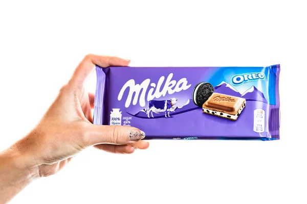 Milka alpine Milchschokolade. Studioaufnahme, Frau hält eine Milka in der Hand — Stockfoto